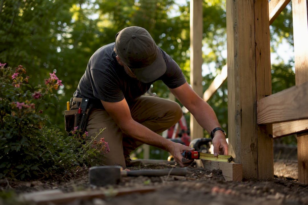 Contractor measuring fence line with tape measure