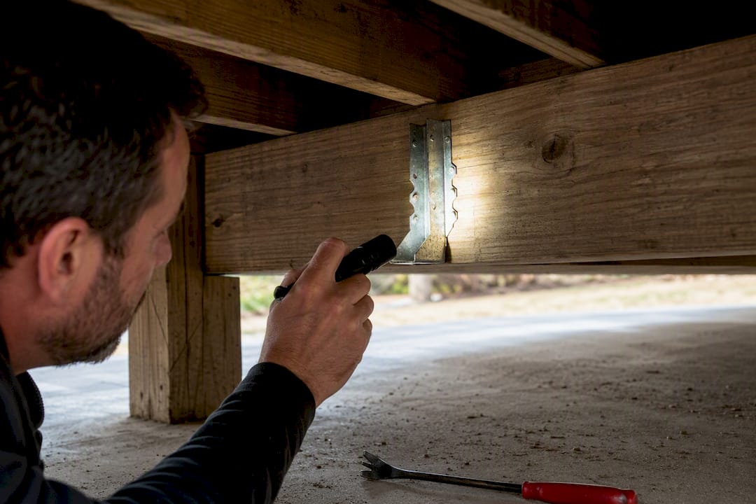 Flashlight revealing deck joist hanger connection