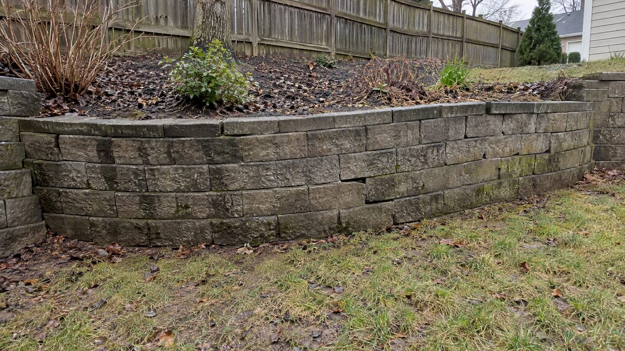 Outward-bowed retaining wall in a backyard